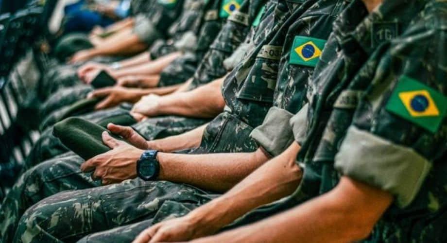 Silhueta de jovem em frente a um terminal de computador, preenchendo formulário digital de alistamento militar, com elementos geométricos que remetem ao litoral de Garopaba ao fundo.