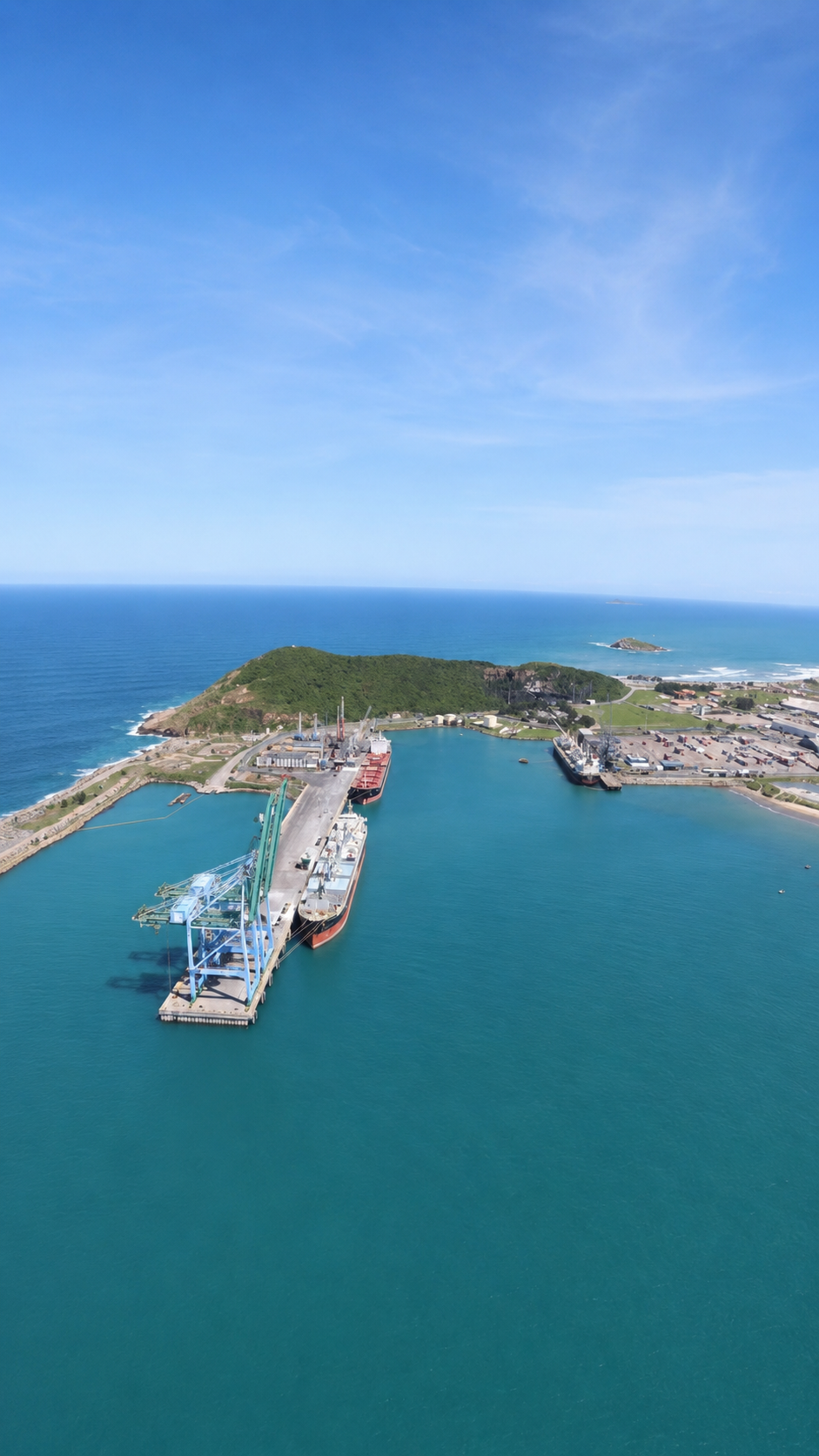Porto de Imbituba com navios atracados, guindastes em operação e movimentação de cargas no cais, evidenciando atividade portuária intensa.