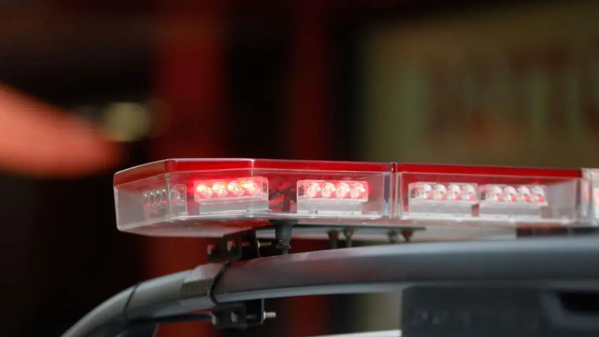 Operação de barreira da PM em Imbituba: silhuetas de policiais militares fiscalizando motocicletas em via pública durante operação de trânsito.